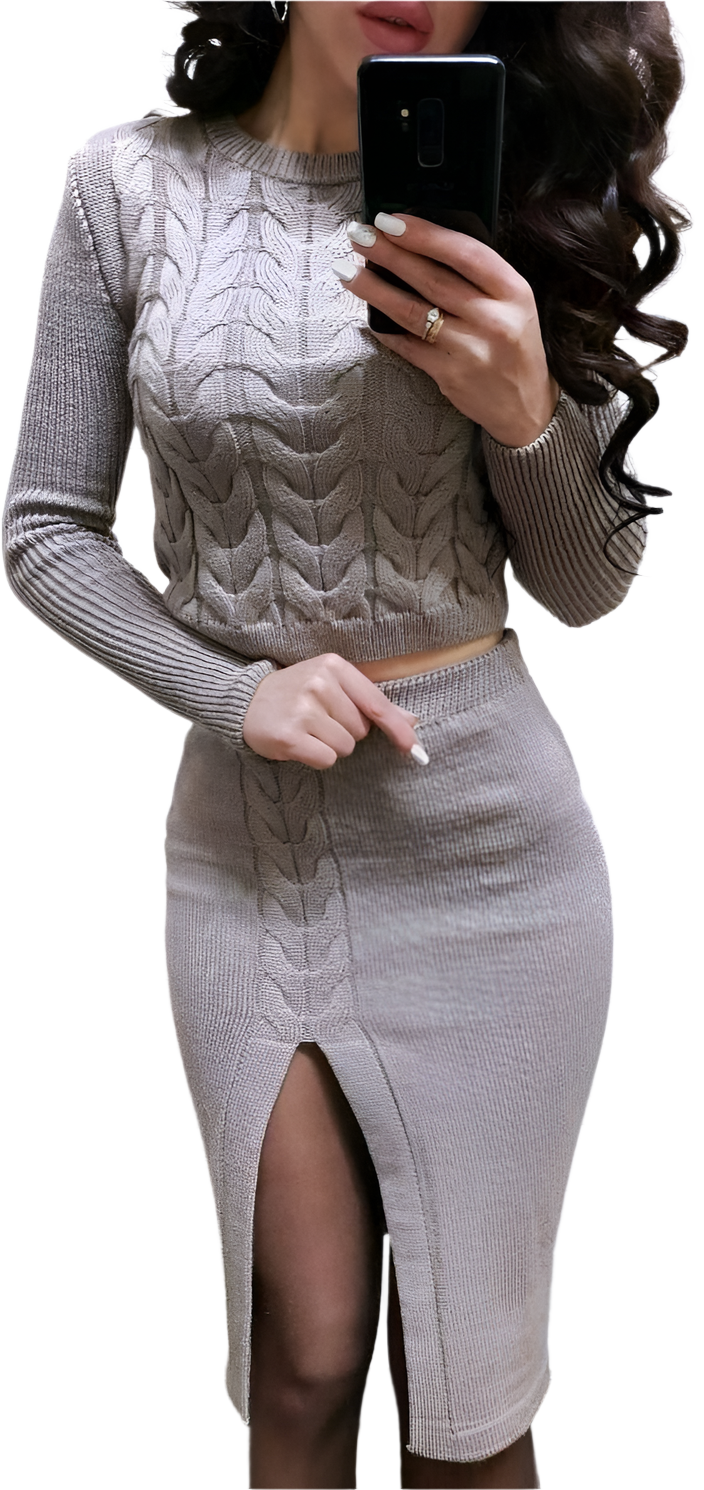 Woman wearing a gray cable knit sweater and skirt set, holding a phone.