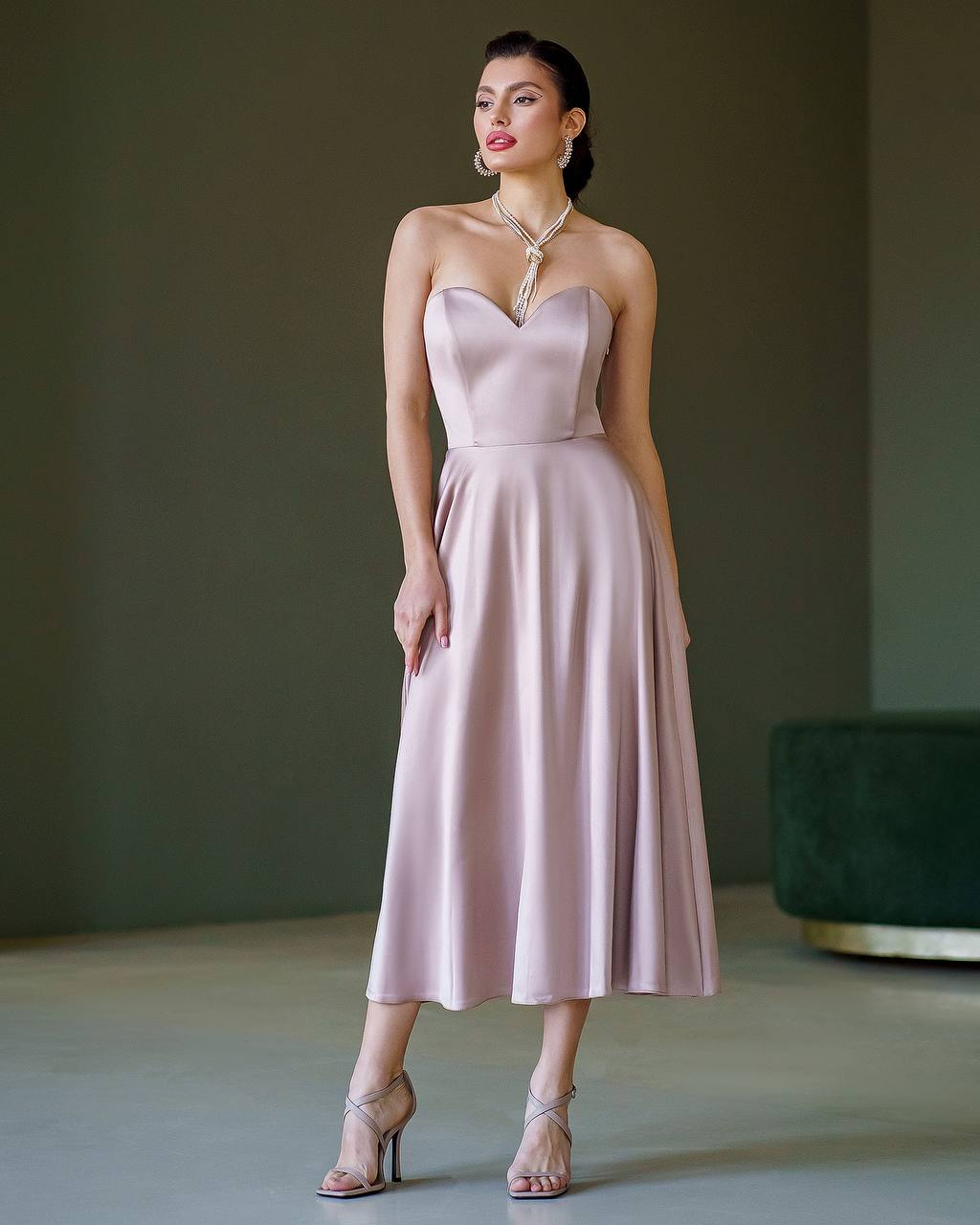 Woman wearing a pink strapless dress against a neutral background