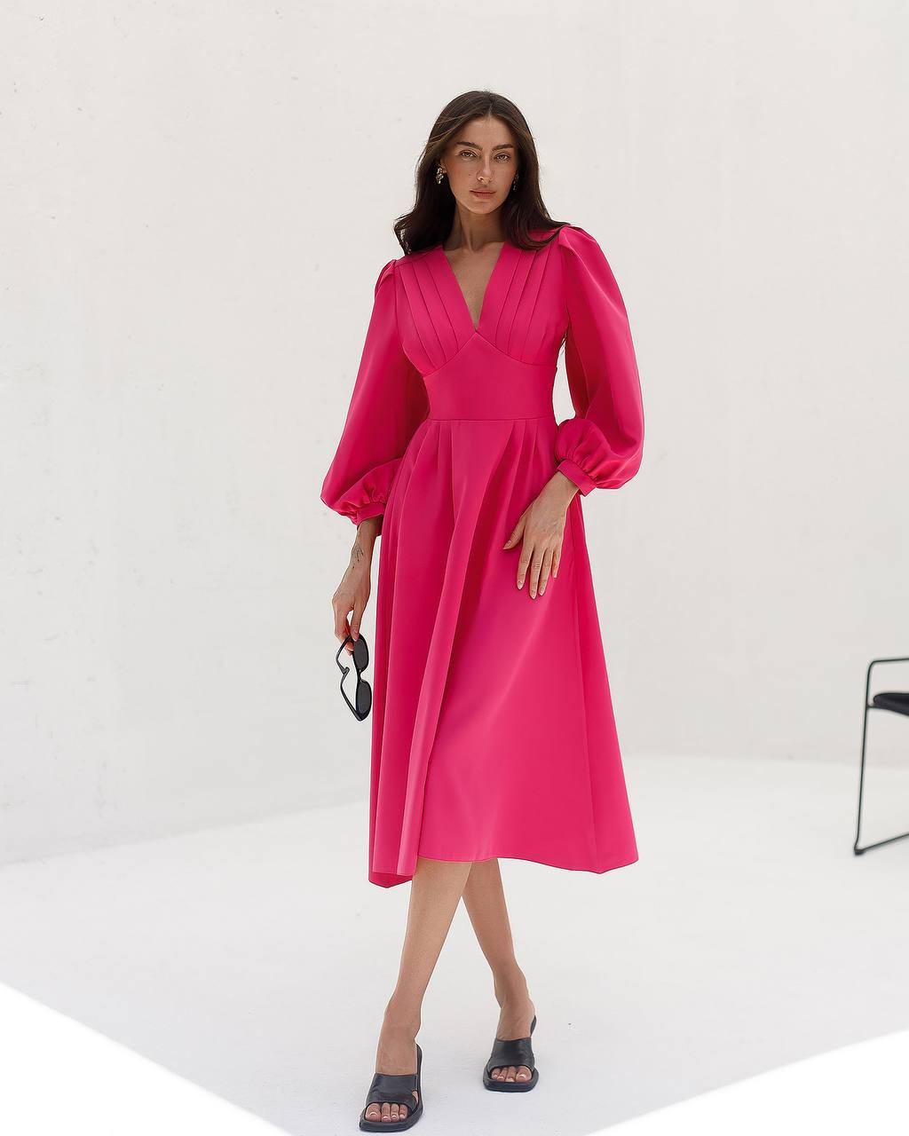 Woman wearing a bright pink dress on a white background