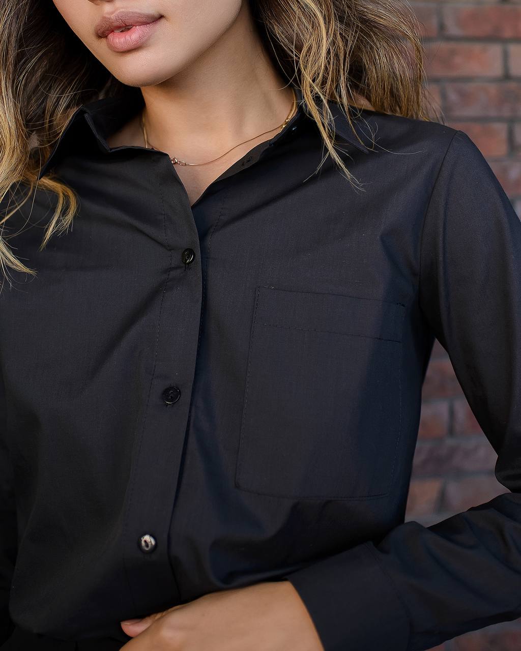Person wearing a black shirt with a blurred background