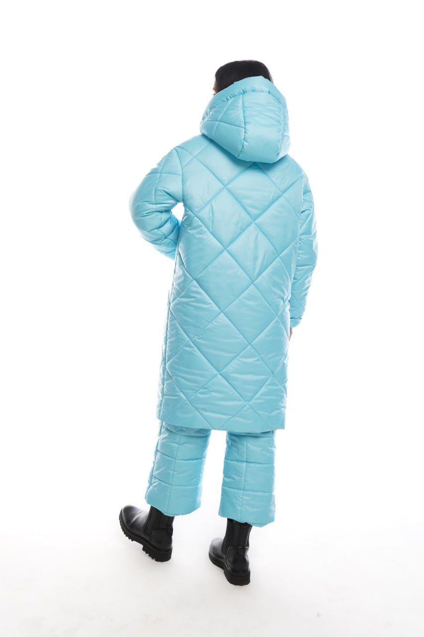 Person wearing a light blue quilted snowsuit on a white background