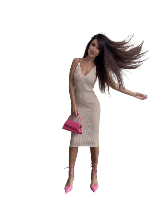 Woman in a beige dress with long hair and pink shoes on a white background