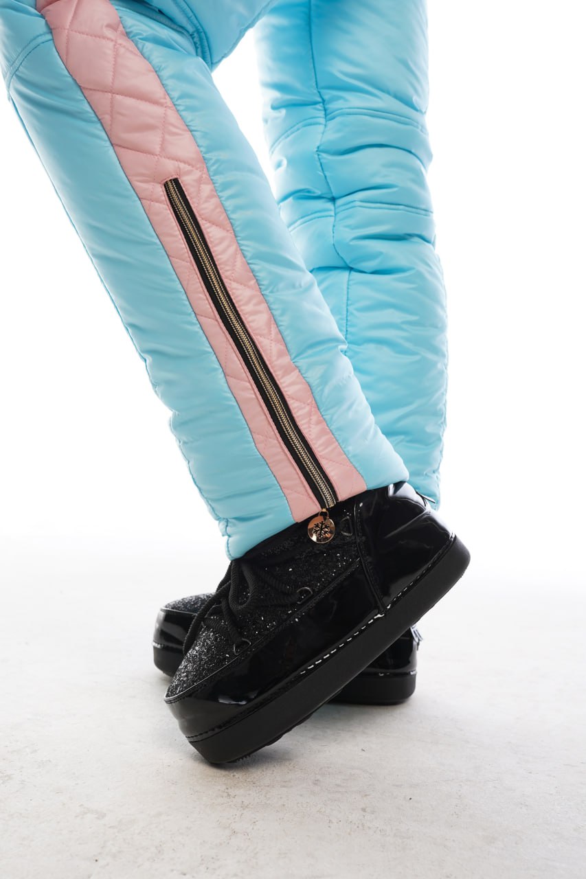 Light blue pants with pink stripes and black shoes on a white background