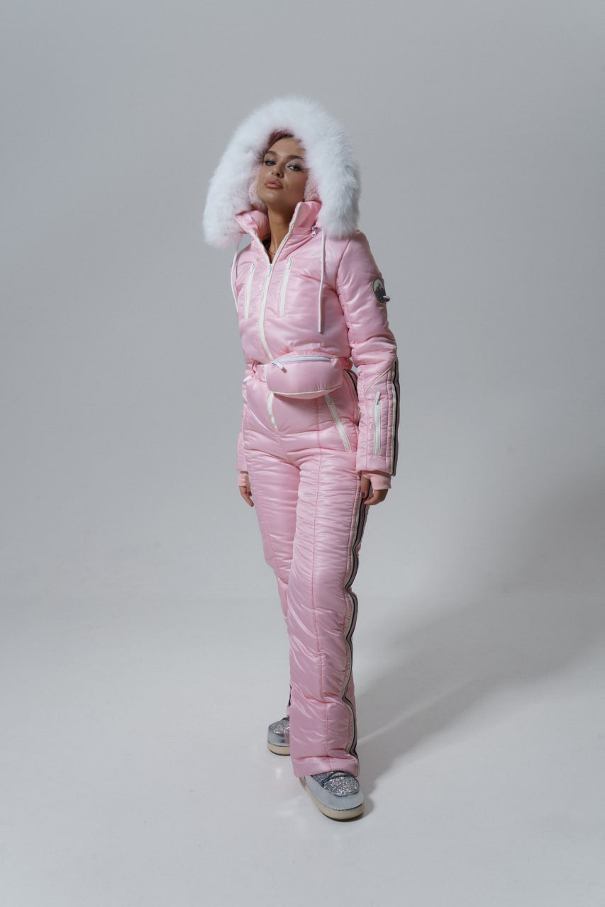 Person wearing a pink puffer suit with white fur hood on a gray background