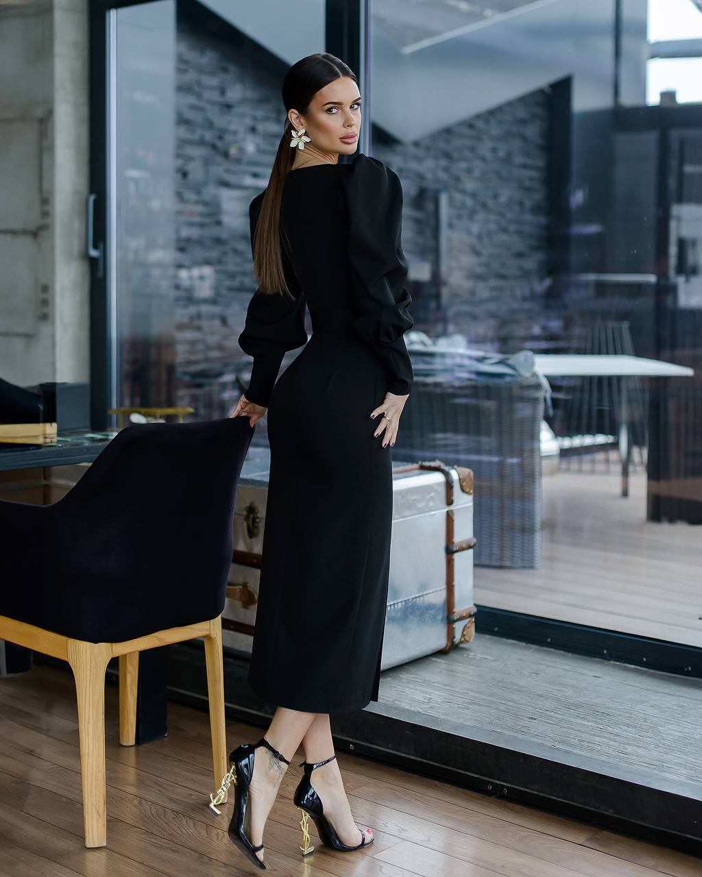 Woman in a black outfit standing in a modern indoor setting