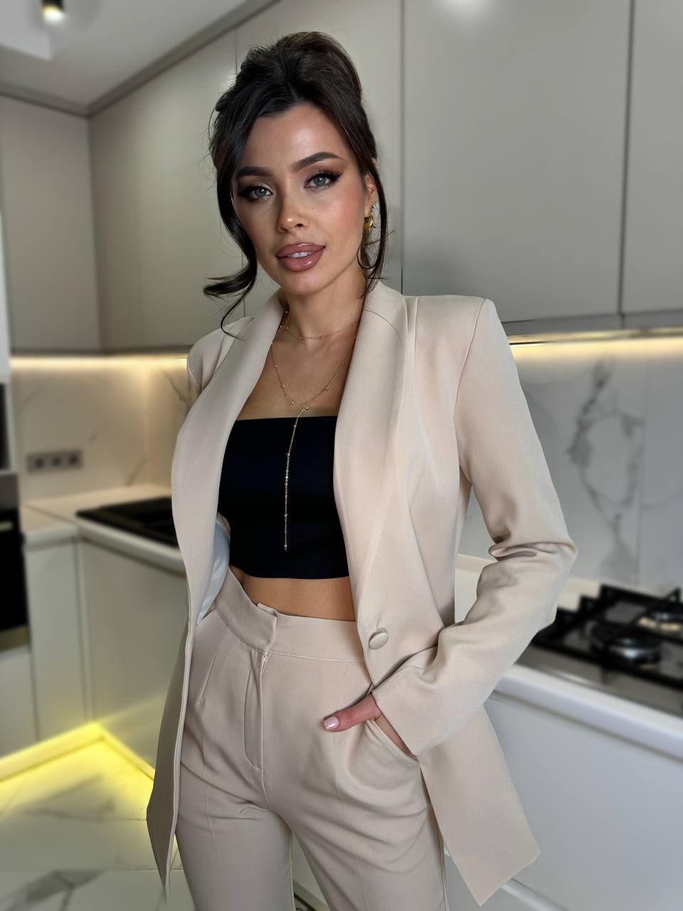 Woman in a beige suit standing in a modern kitchen