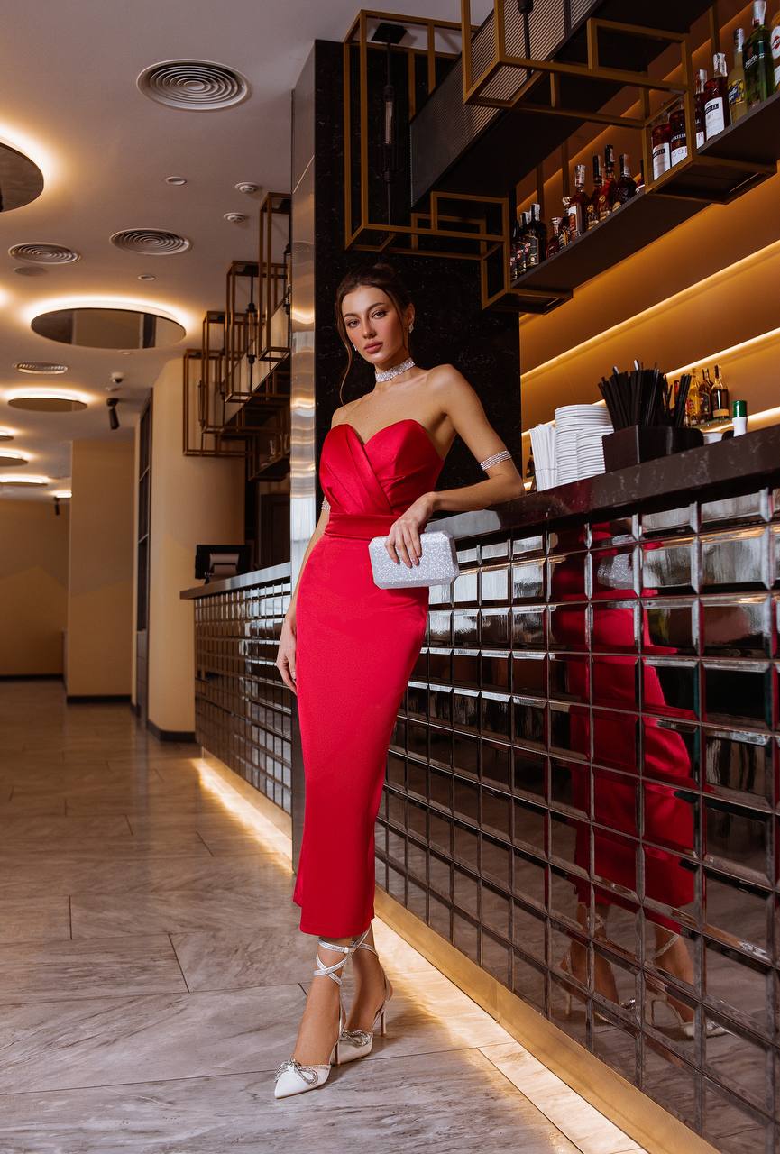 Woman in a red dress standing in a bar setting