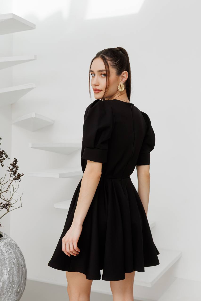 Woman wearing a black dress in a minimalistic setting