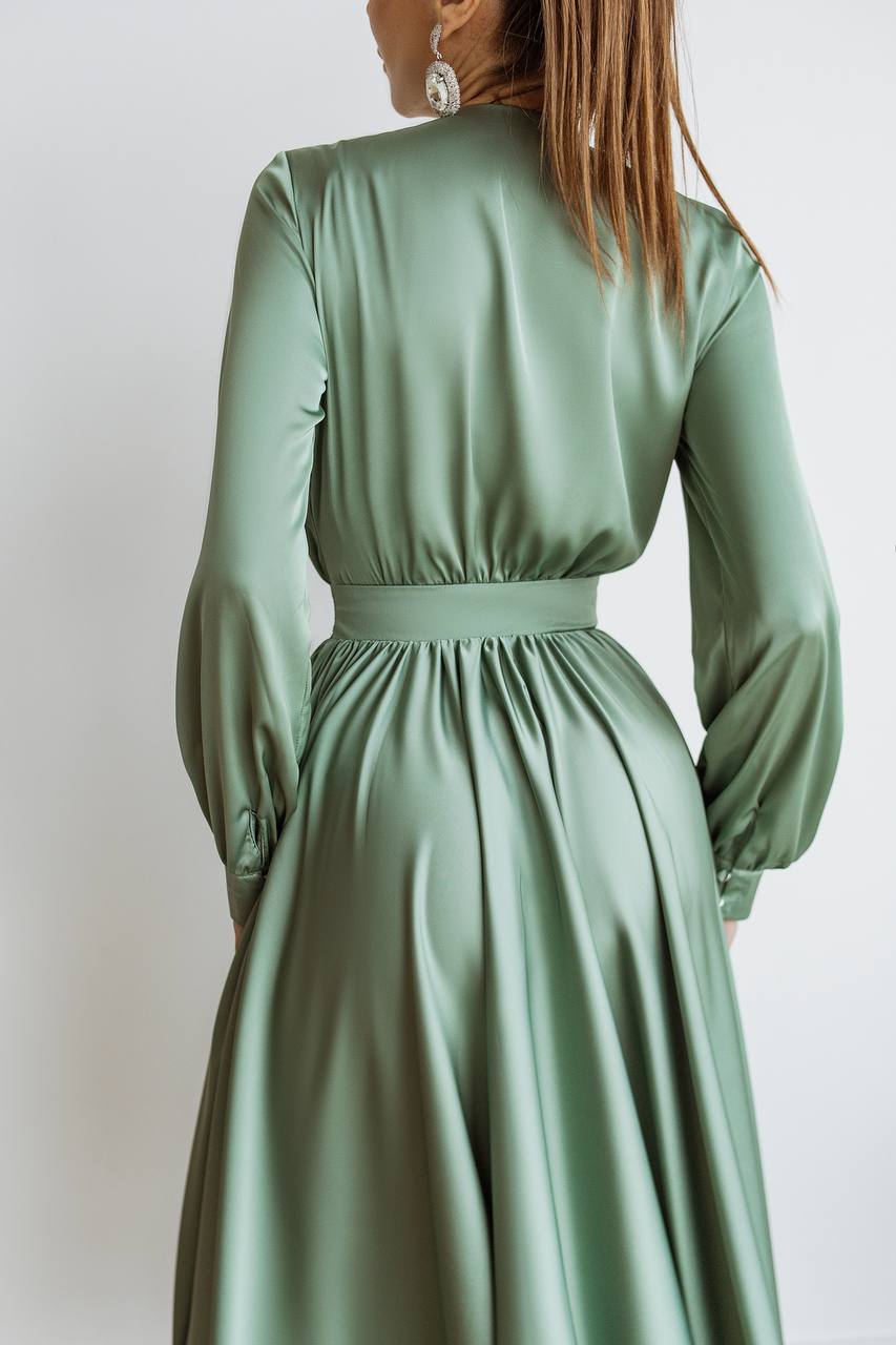 Green dress with long sleeves on a plain background