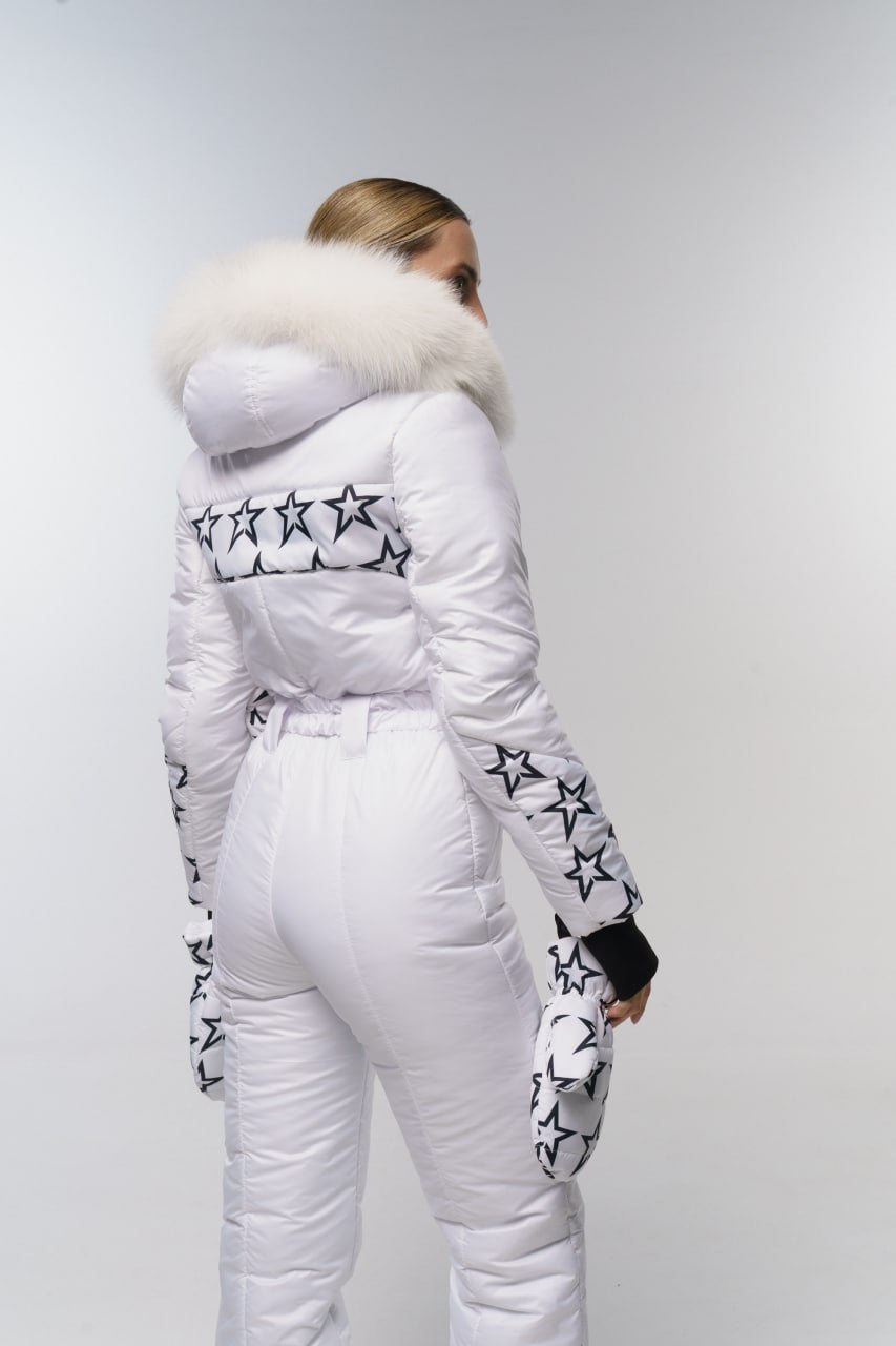 Person wearing a white winter outfit with star patterns on a plain background
