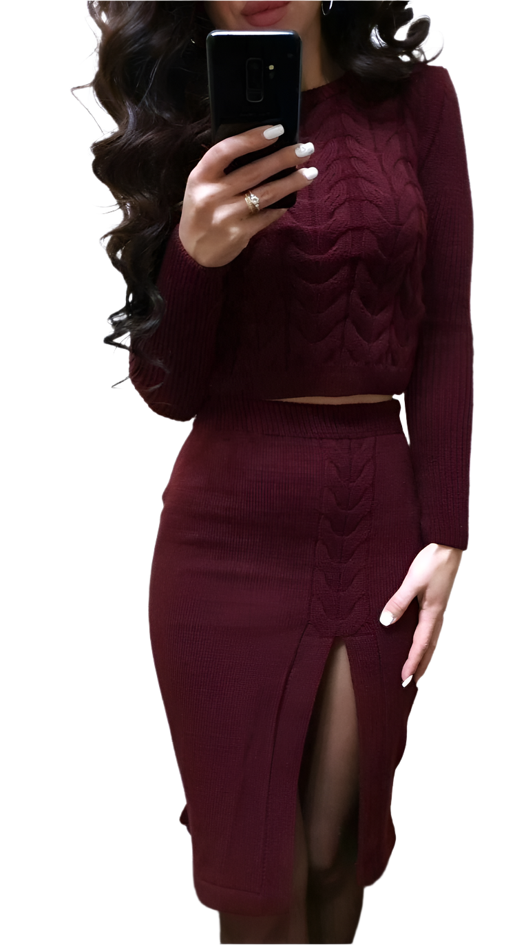 Person wearing a burgundy long-sleeve top and skirt set, holding a phone.