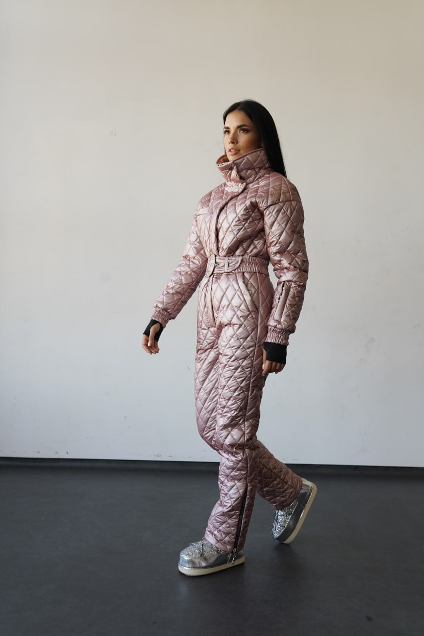 Person wearing a pink quilted snowsuit against a plain background