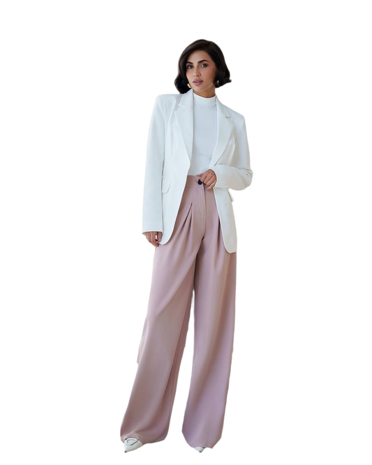 Woman wearing a white blazer and pink pants on a white background