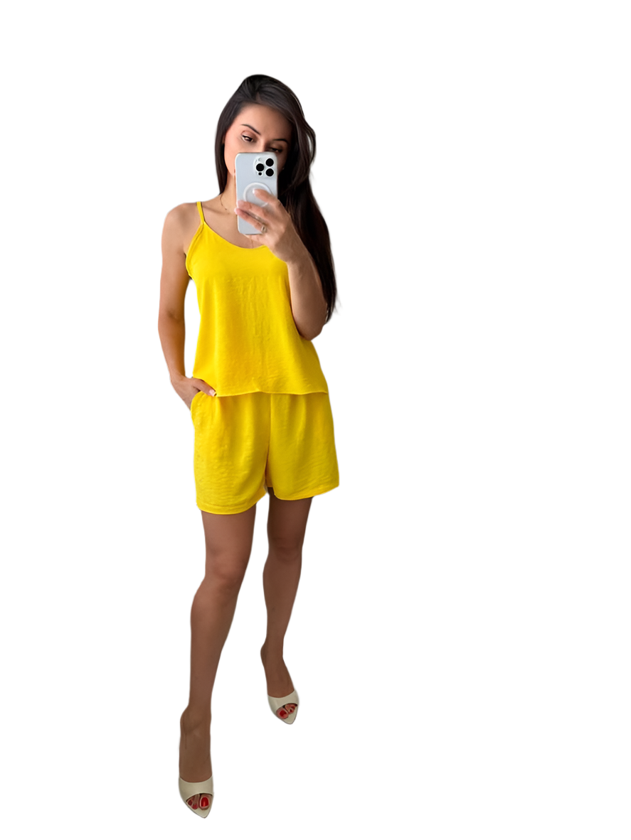 Woman taking a selfie wearing a yellow outfit on a white background