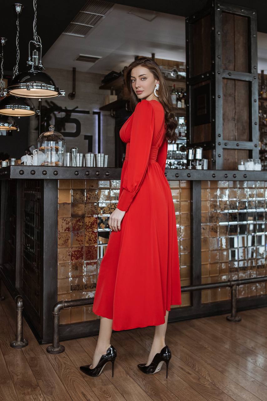 Woman in a red dress standing in a stylish interior setting