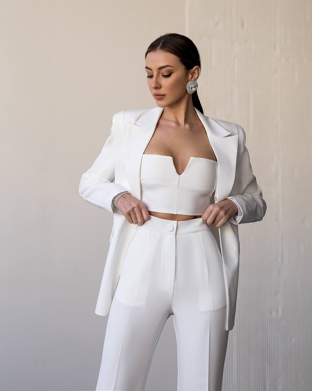 Woman wearing a white suit with a plain background