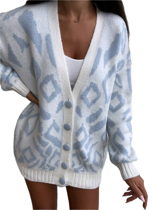 White cardigan with blue geometric pattern worn by a person on a white background