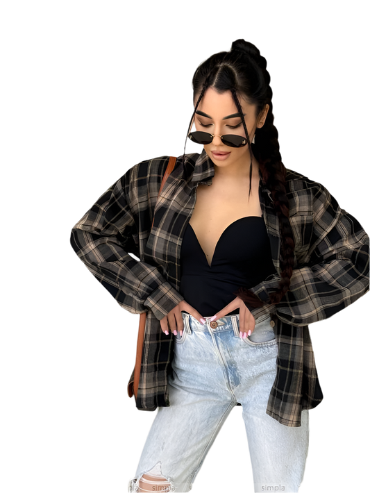 Woman wearing a plaid shirt, black top, and light blue jeans on a white background