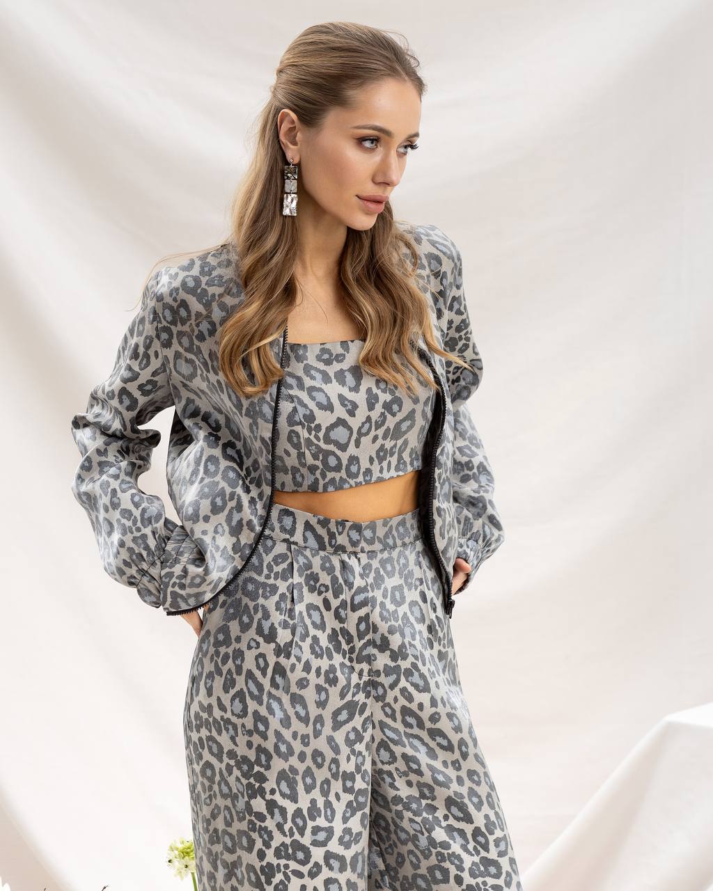 Woman wearing a gray leopard print outfit against a light background