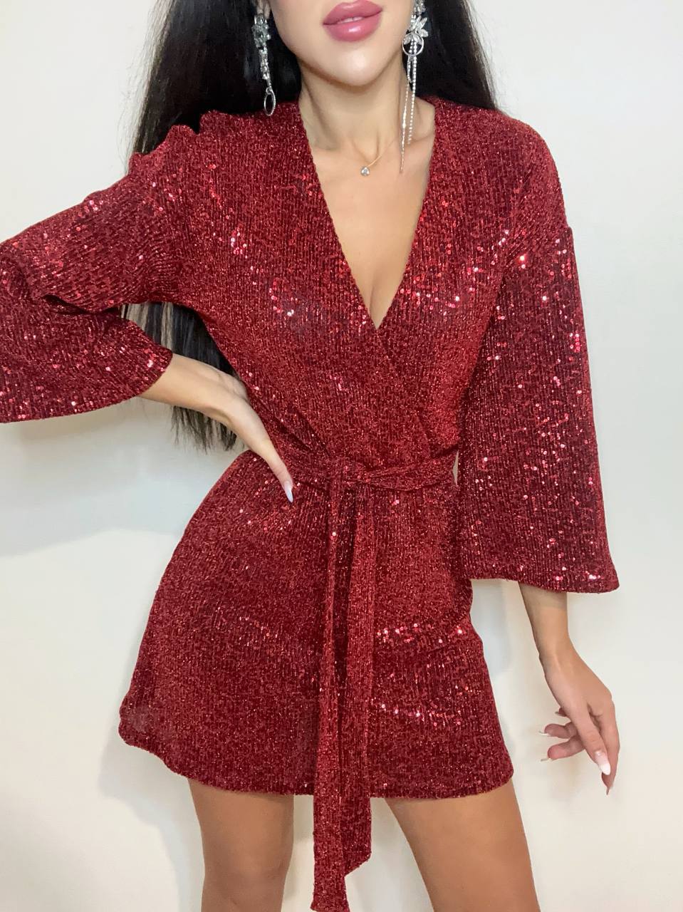 Red sequin dress worn by a model on a white background