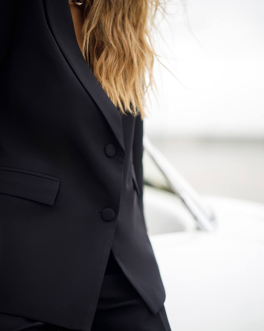 Person wearing a black suit with blurred background