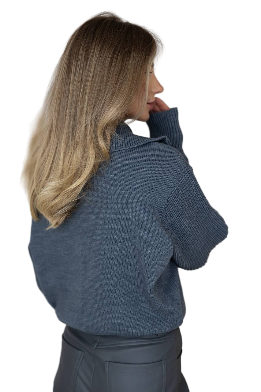 Woman wearing a blue sweater against a white background