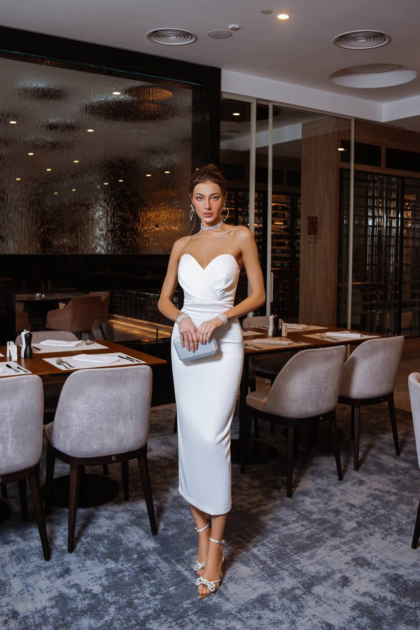 Woman in a white dress standing in a restaurant setting