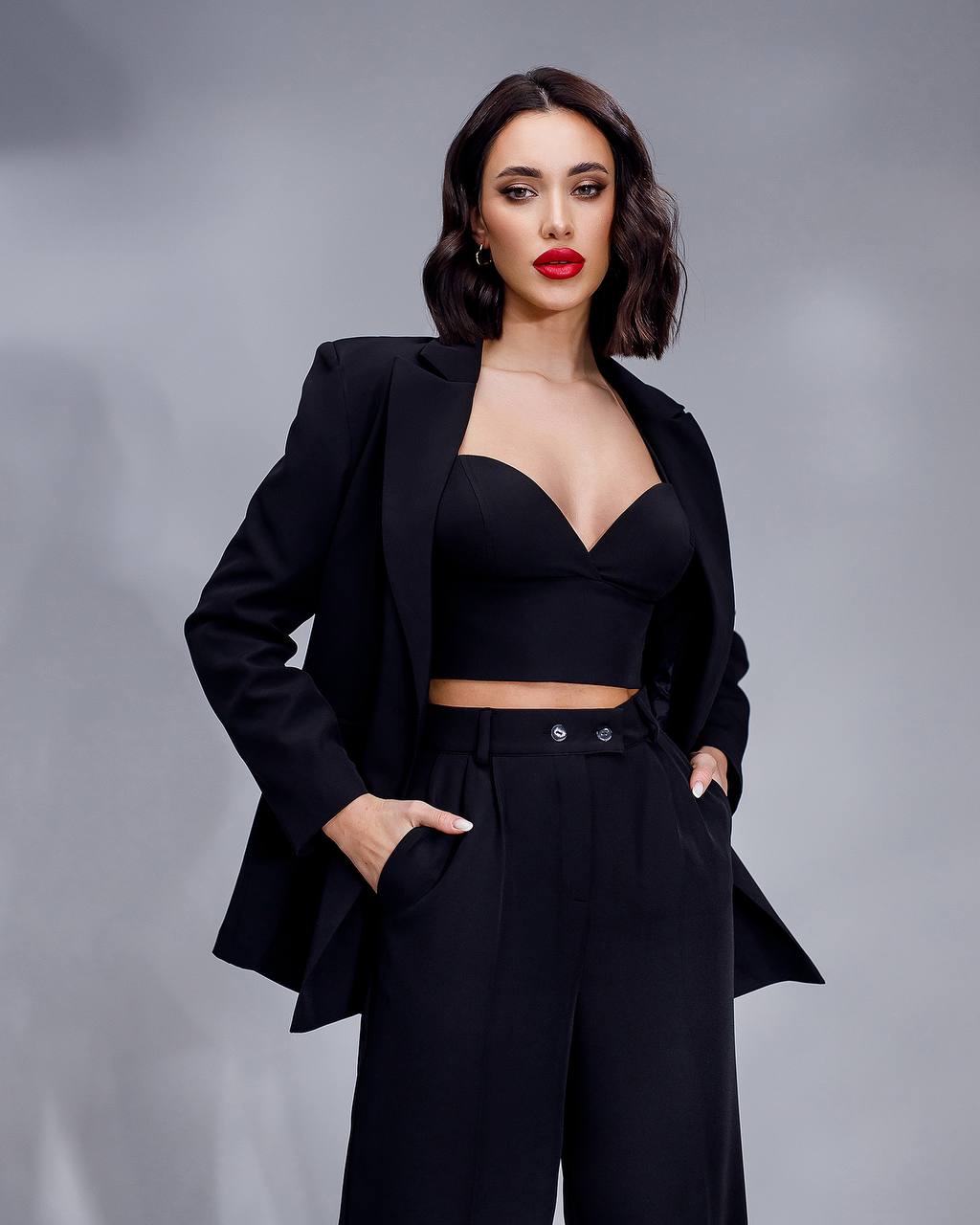 Woman wearing a black suit with a gray background