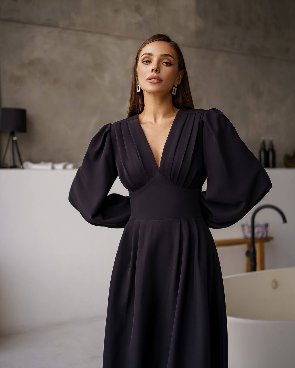 Woman wearing a dark blue dress in an indoor setting