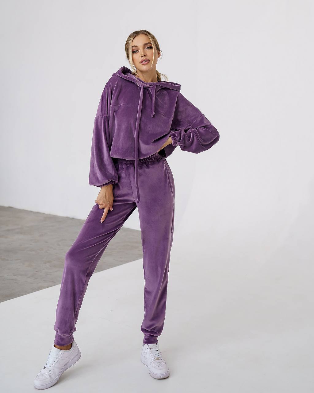 Woman wearing a purple tracksuit on a white background