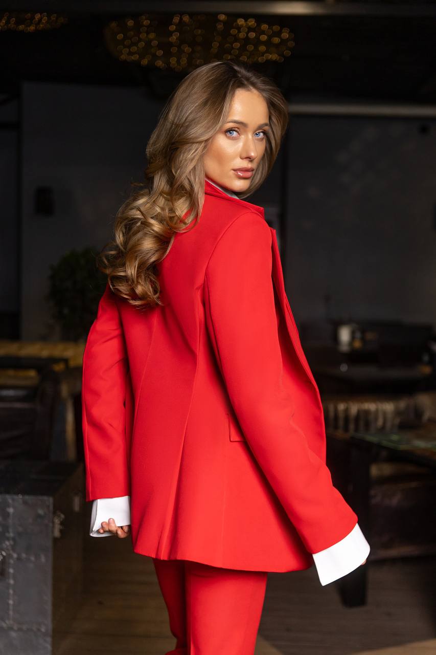 Woman wearing a red coat with a blurred indoor background