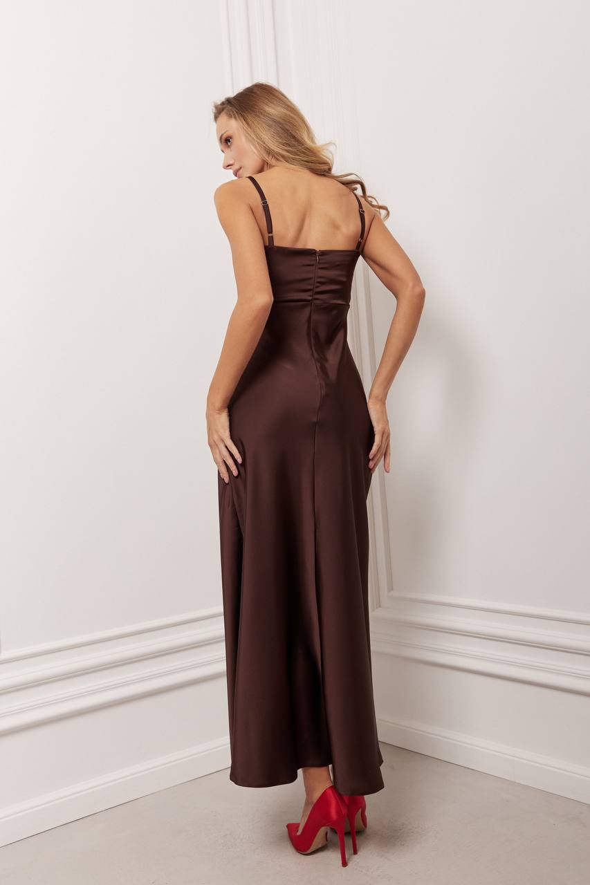 Woman wearing a brown evening gown with red high heels in an elegant room.