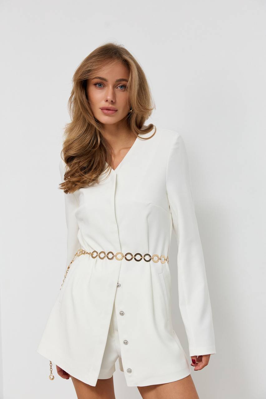 Woman wearing a white blazer with a gold belt on a white background