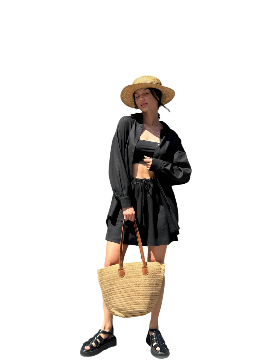 Woman in black outfit with straw hat and bag on a white background