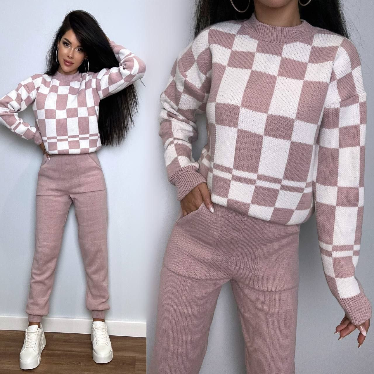 Person wearing a pink and white checkered sweater and pants set against a plain background