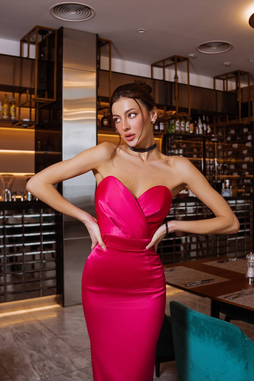 Woman in a pink dress posing in a restaurant setting