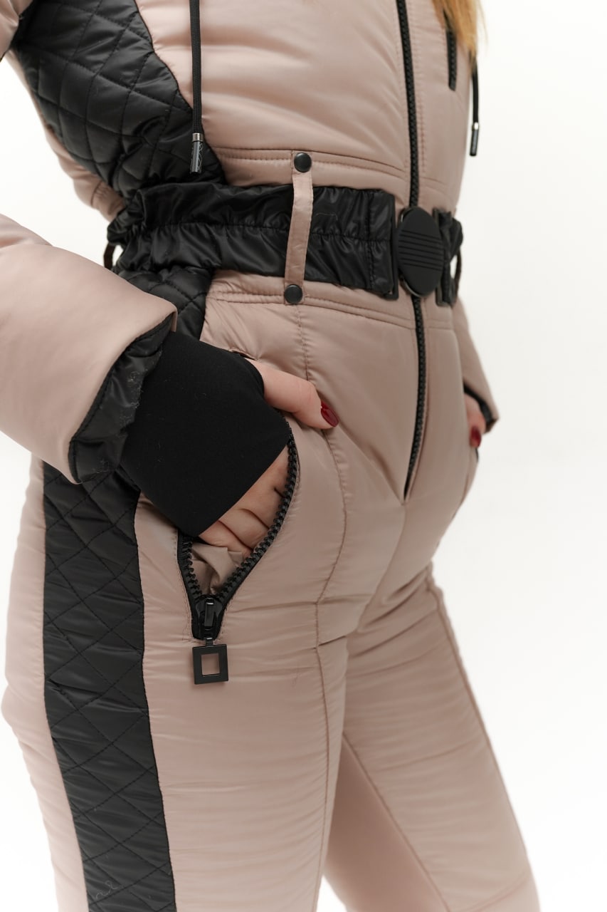 Close-up of a person wearing a beige and black winter outfit with a white background