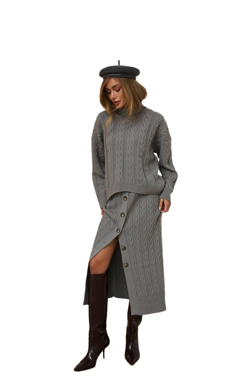 Woman wearing a gray knit dress with a slit, black boots, and a black beret on a white background