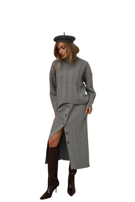 Woman wearing a gray knit dress with a slit, black boots, and a black beret on a white background