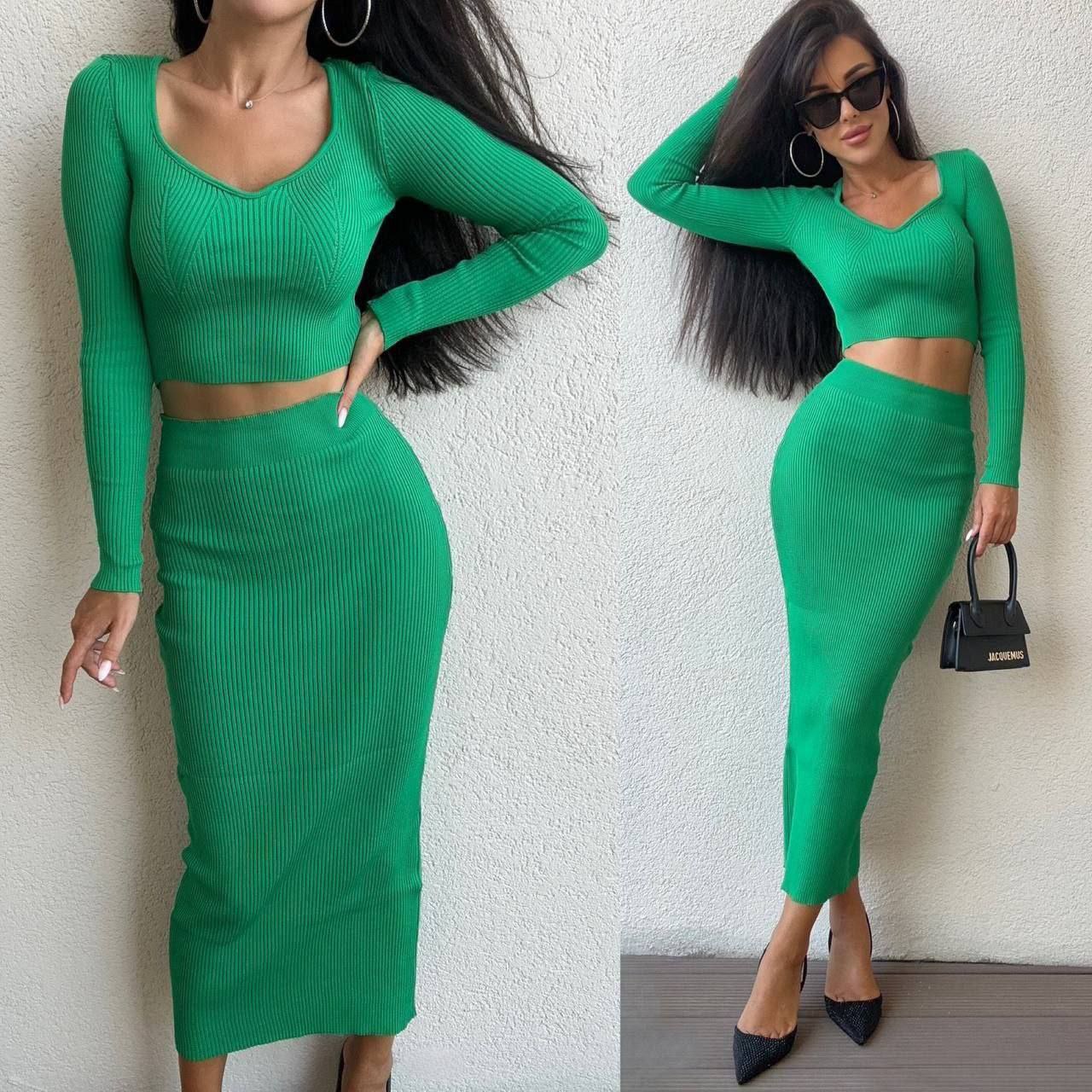 Woman wearing a green two-piece outfit with a white background