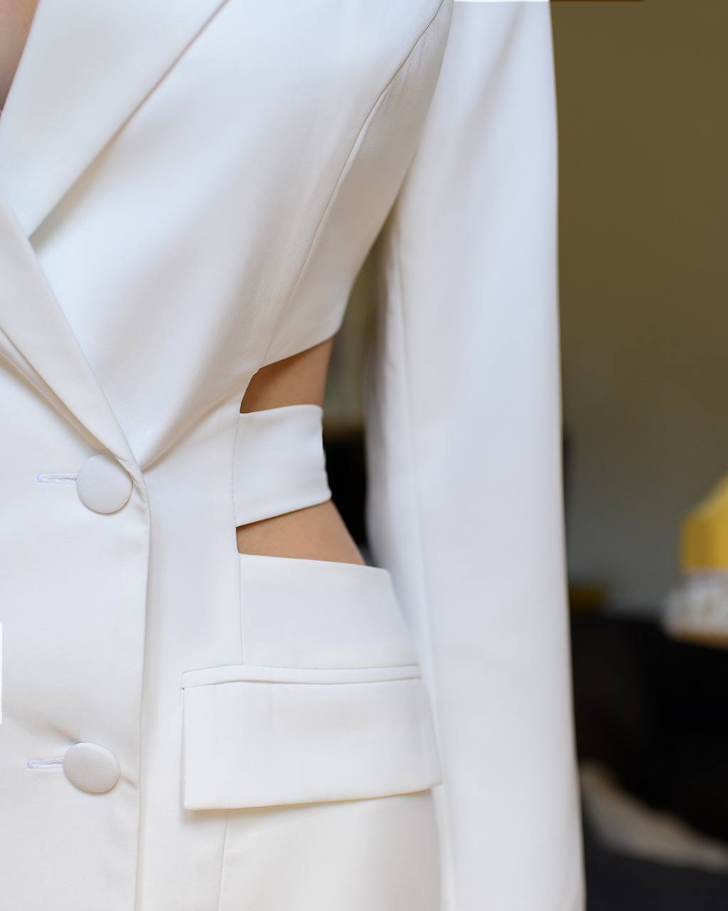 Close-up of a white blazer with a blurred background