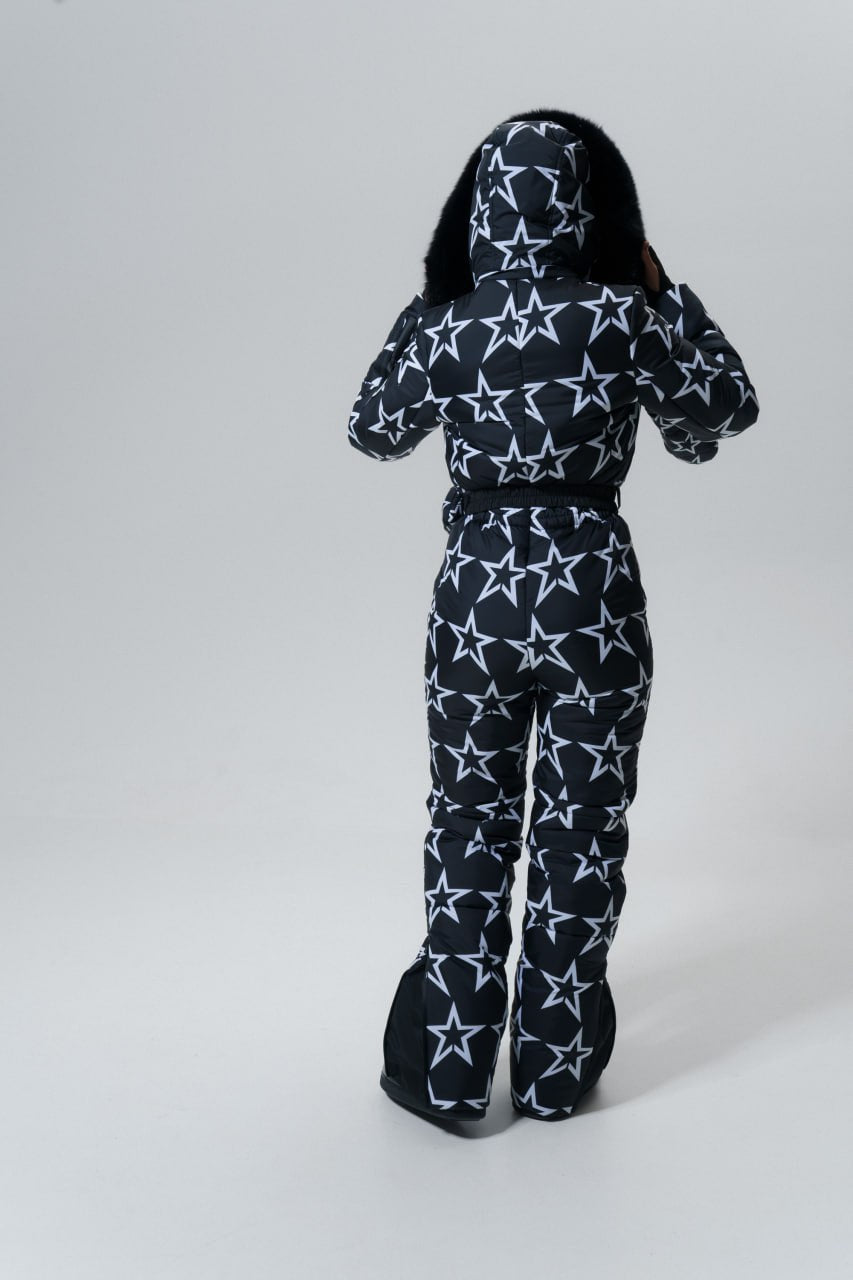 Black onesie with white star pattern worn by a person on a white background