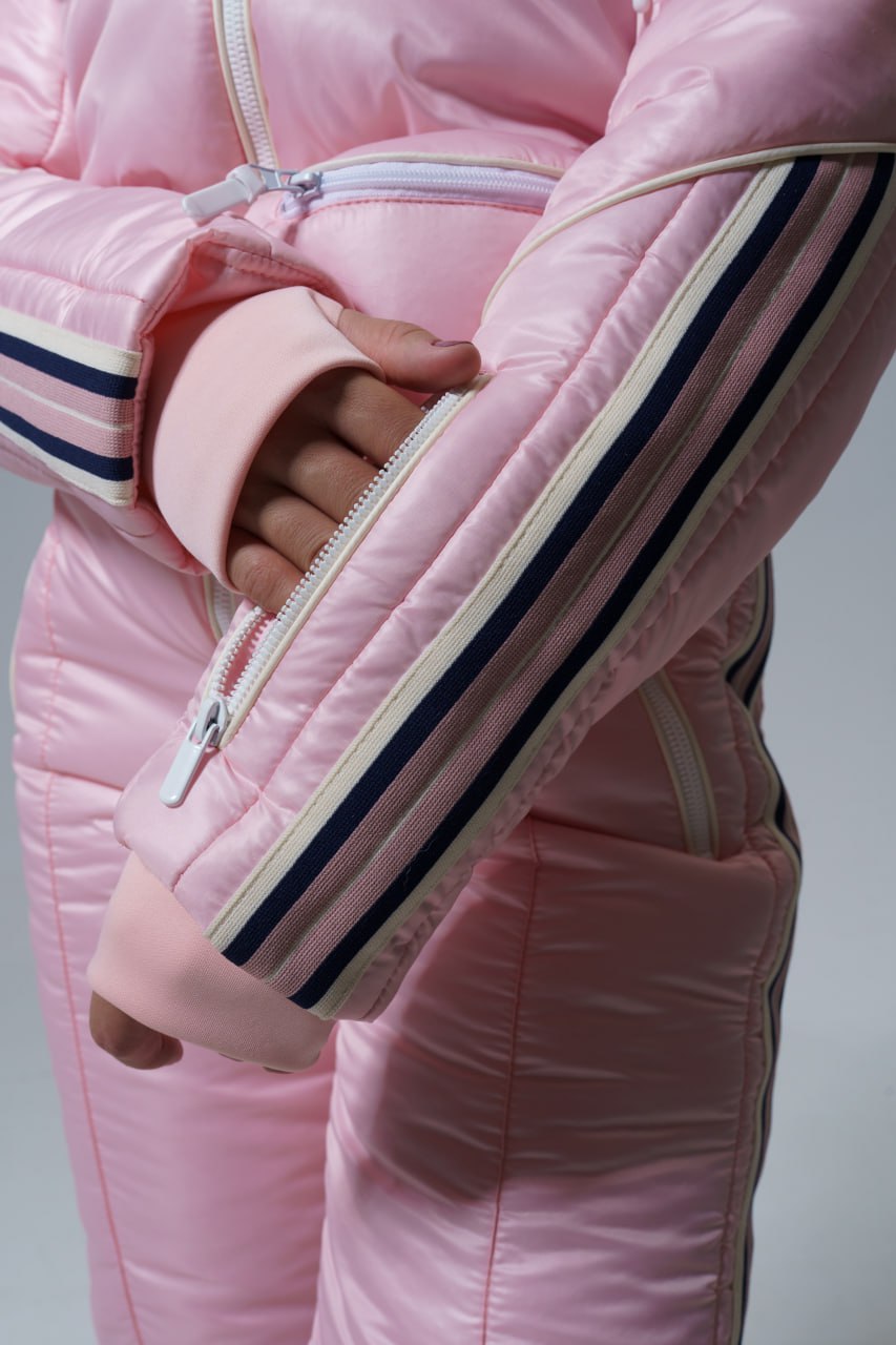 Close-up of a pink puffer jacket with striped cuffs on a gray background