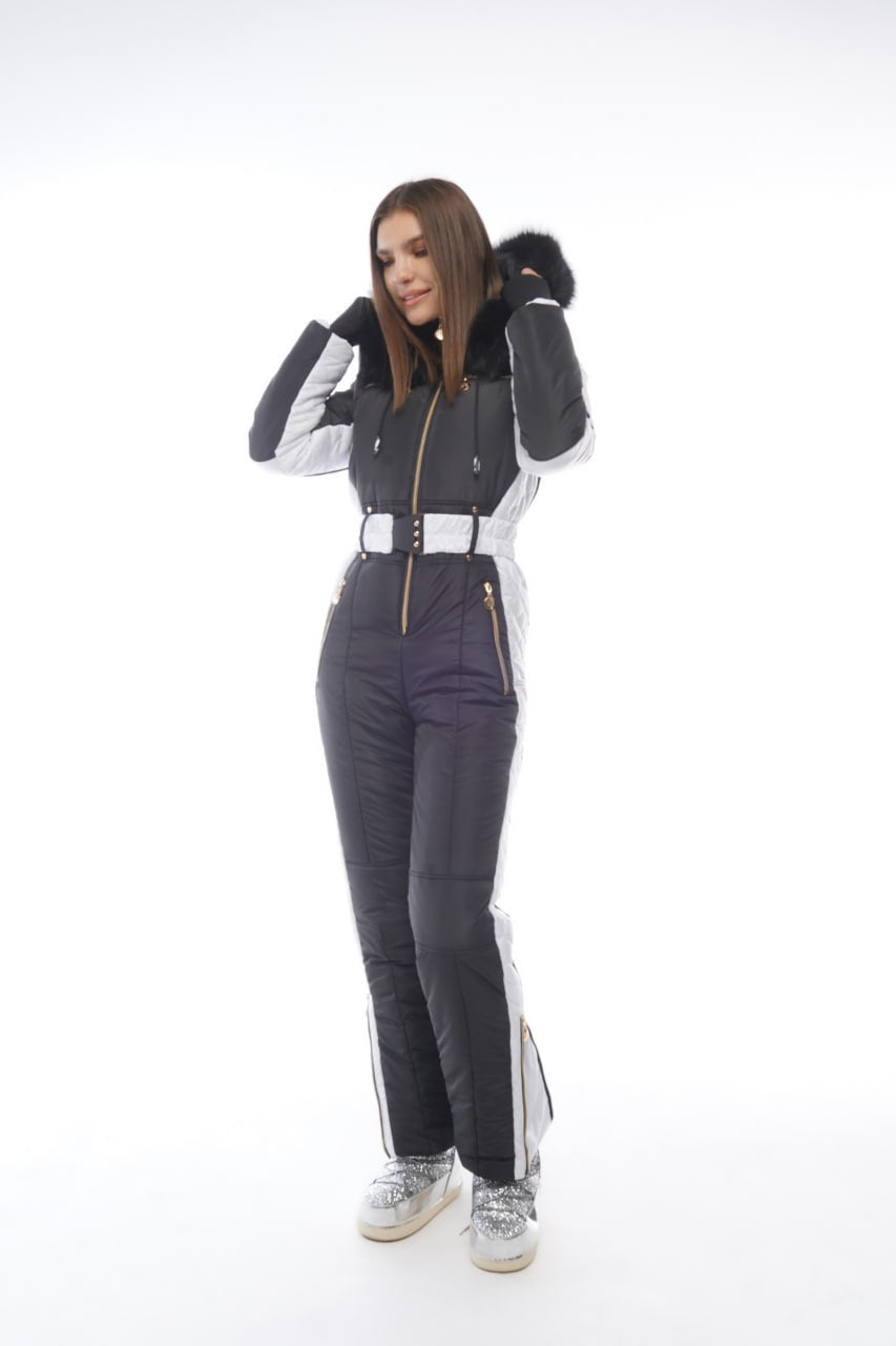 Person wearing a black and white ski suit on a white background