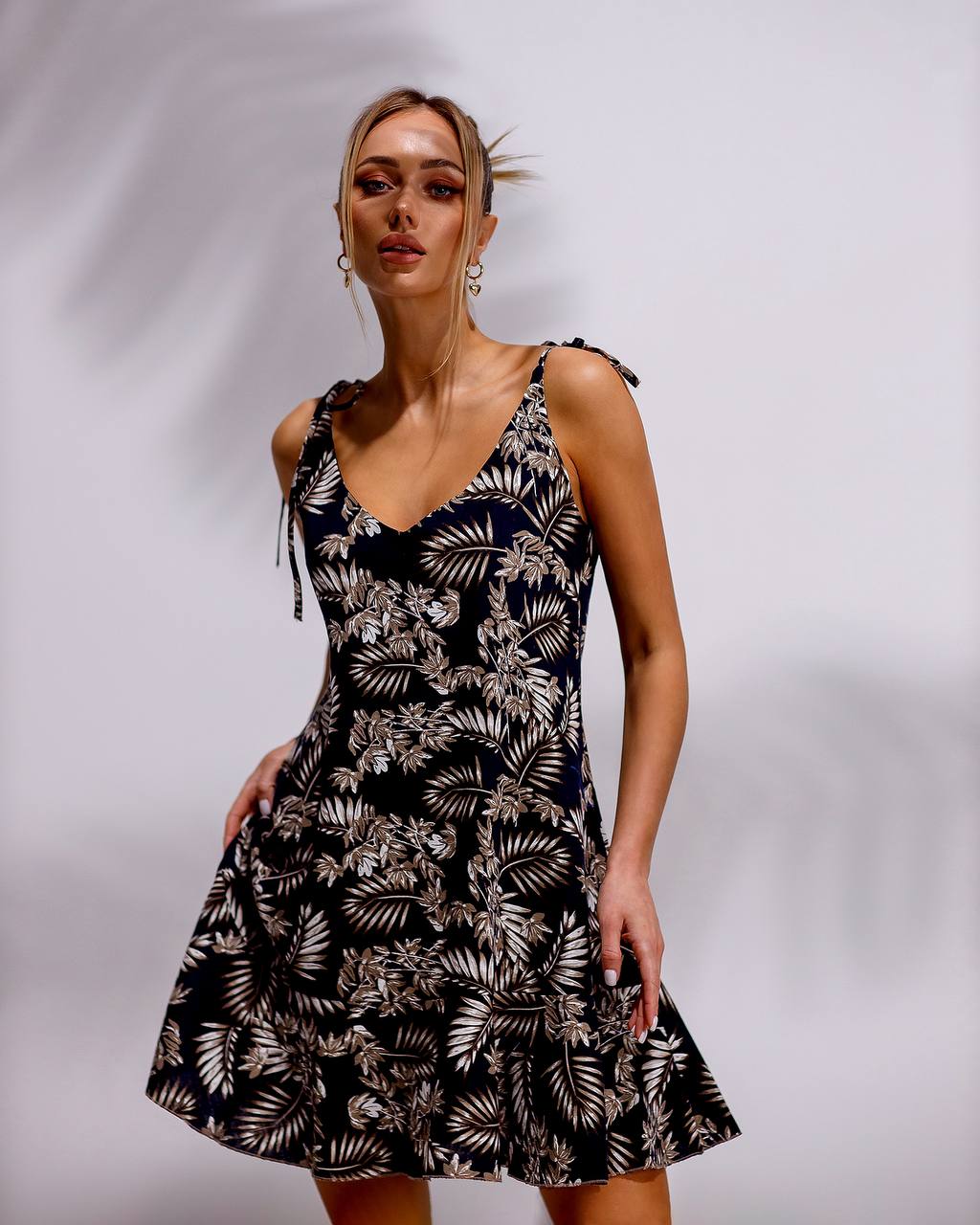 Woman wearing a black and white floral dress against a plain background