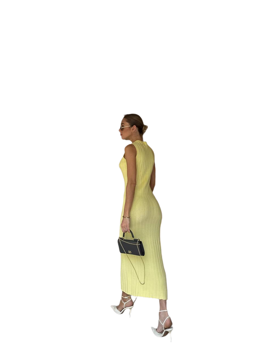 Woman wearing a yellow dress holding a black handbag on a white background