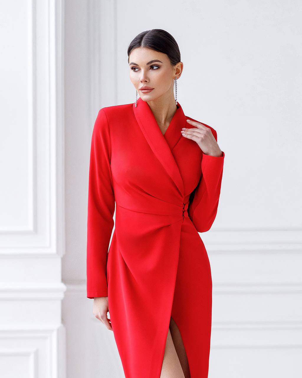 Woman wearing a red dress against a white wall