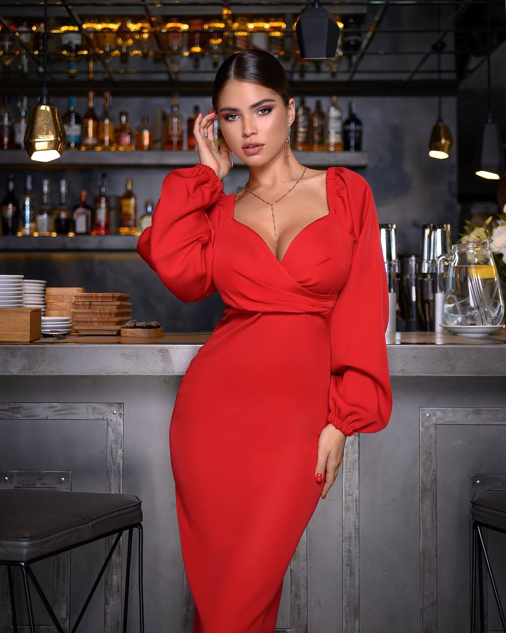 Woman in a red dress standing in a bar setting