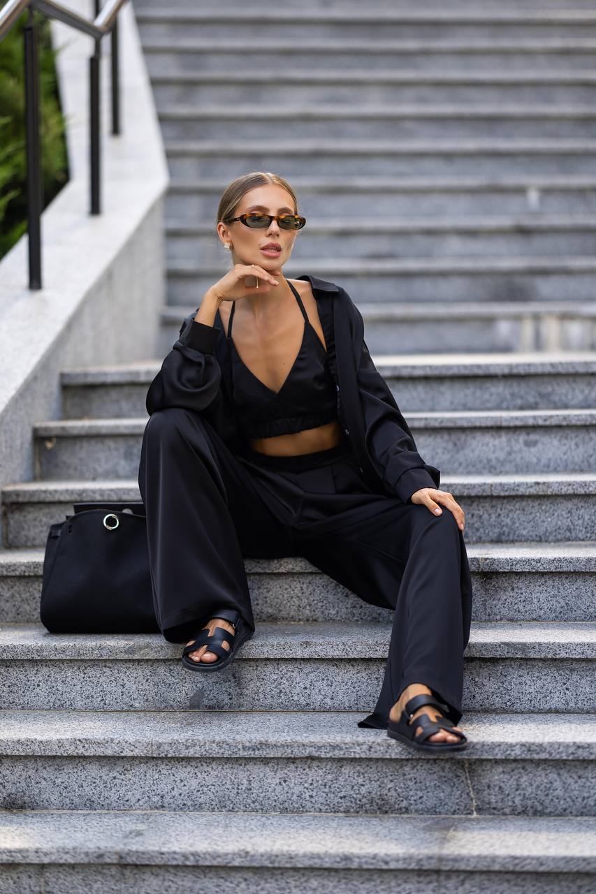 Woman in black outfit sitting on stone steps