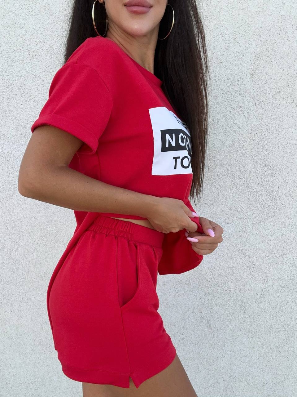 Person wearing a red outfit with a logo on a light gray background